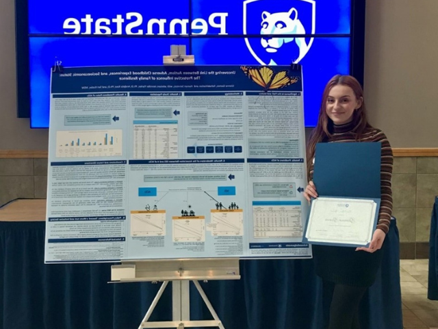 Gianna Gomes standing in front of her research poster