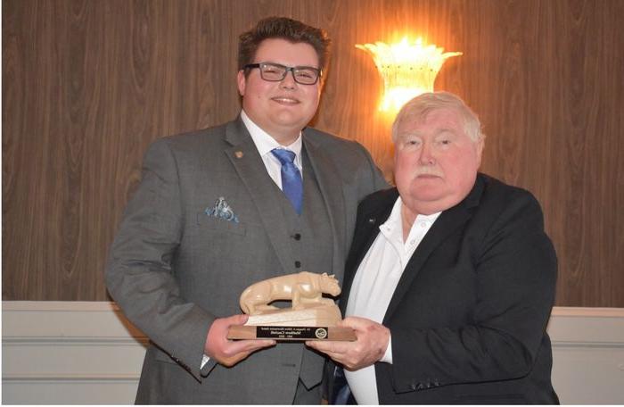 Image of Matt Cascioli and man holding Lion shrine statue.