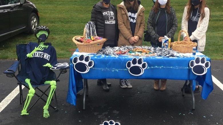 students at table handing out candy