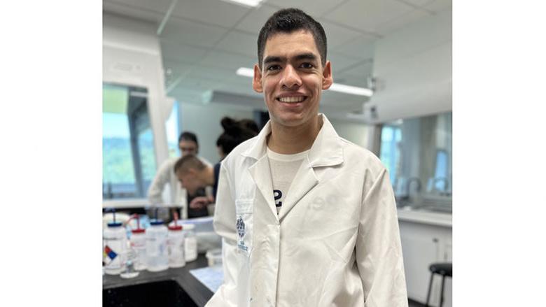 College student wearing lab coat in college laboratory.