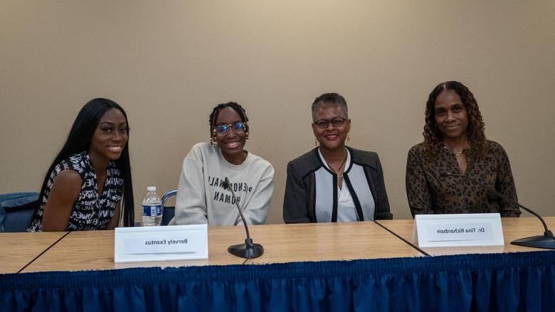 Panelists pose for pictures at table 