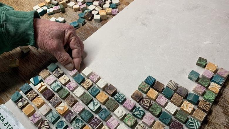 A person working on a mosaic tile project