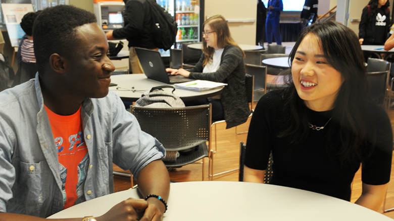 Two students sitting at a table in Lion's Den cafeteria